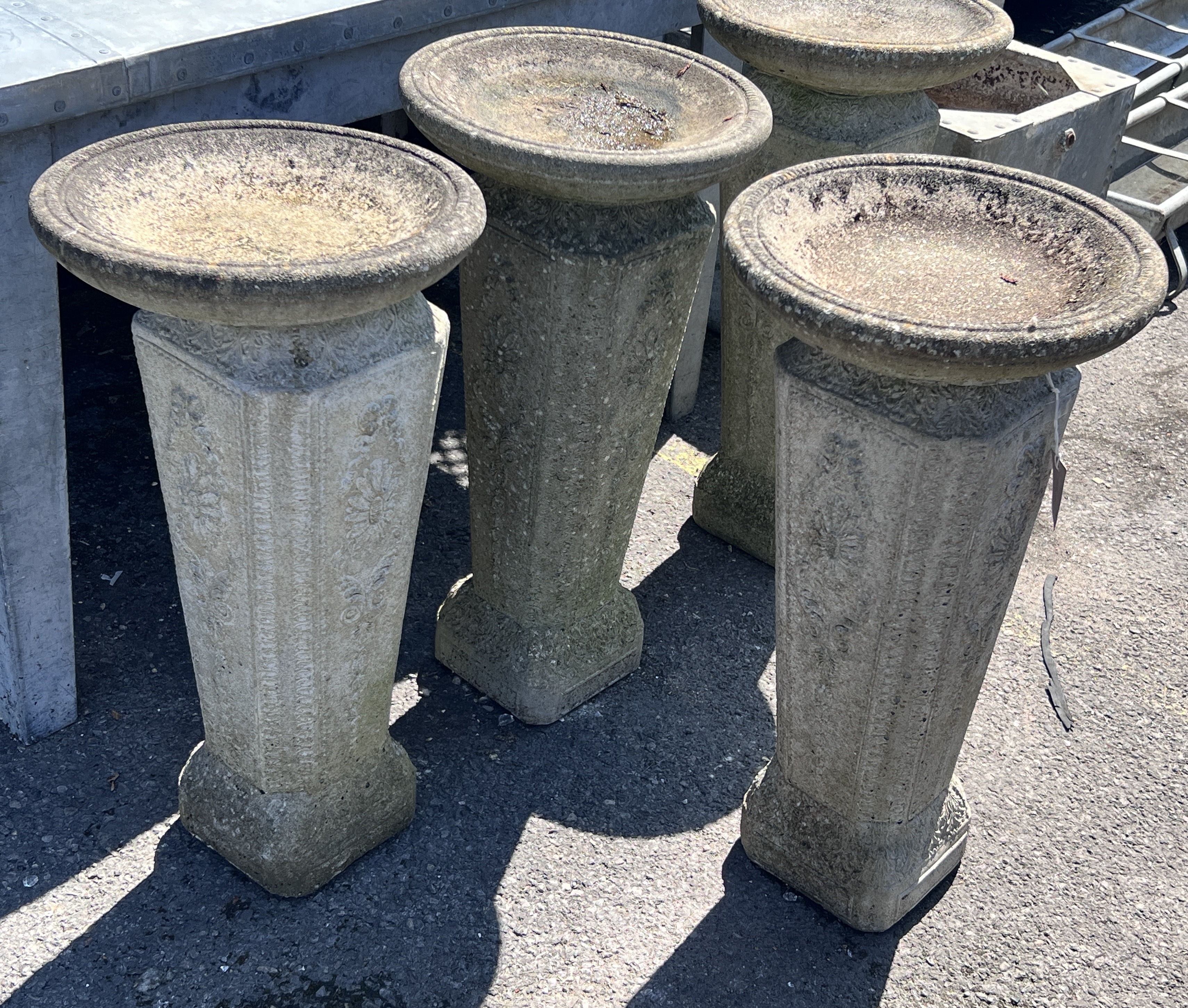 A set of four reconstituted stone circular bird baths, height 74cm